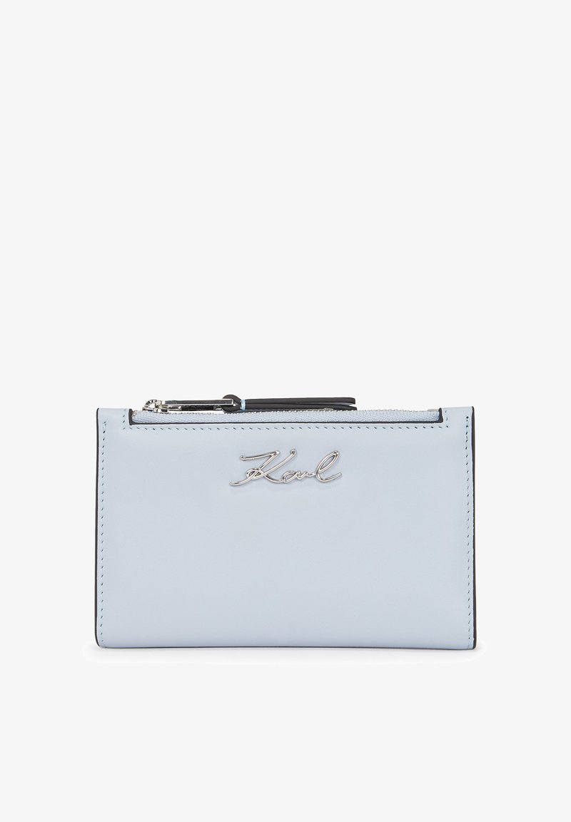 Gaiši zils ādas maciņš ar sudraba apdari, ar rāvējslēdzēja aizdari un izsvarotu 'Karl' logotipu priekšpusē. Kompakta taisnstūra forma.