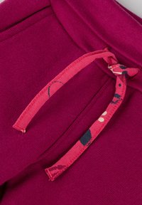 Fuchsie Sweatpants mit strukturiertem Finish, ausgestattet mit einer gemusterten Zugkordel in Pink mit mehrfarbigen Akzenten und einem gebundenen Knoten-Detail.