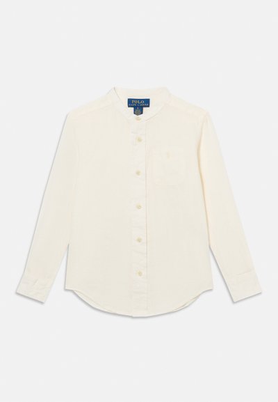 Κρεμ πουκάμισο με μακριά μανίκια, μπροστινά κουμπιά, γιακά μανταρίνι και τσέπη στο στήθος, με την ετικέτα Polo Ralph Lauren ορατή στο εσωτερικό του γιακά.