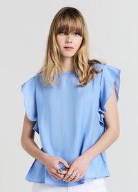 Blouse à manches courtes bleu clair avec plis subtils, encolure arrondie et manches volantées. Texture lisse, coupe décontractée et tombé doux.