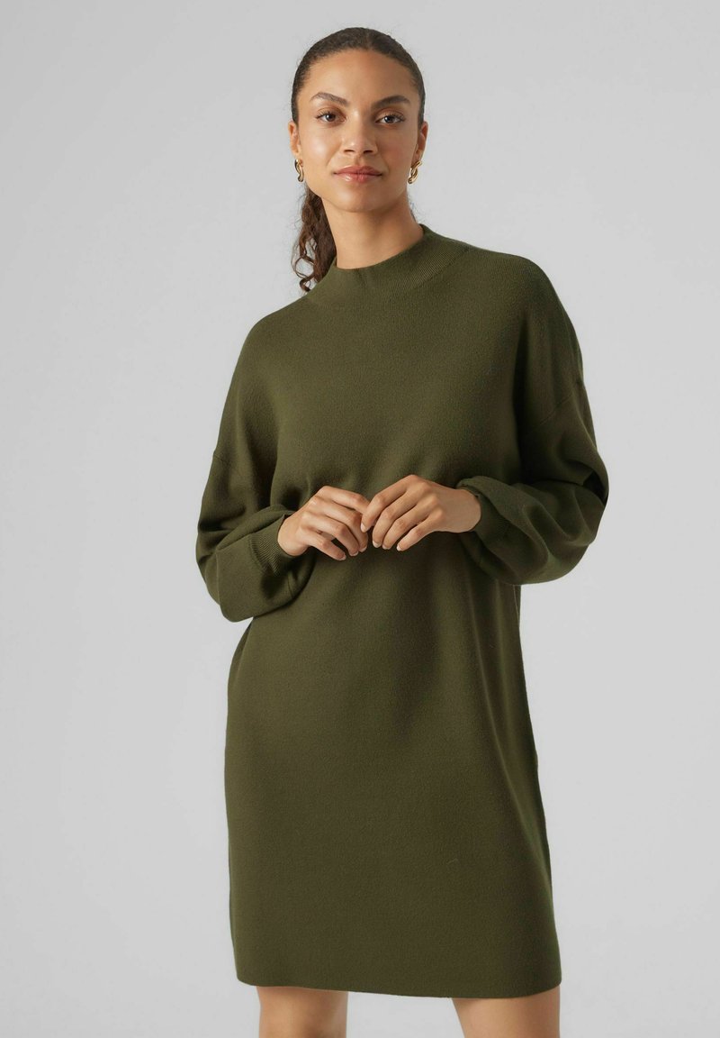 Abito lavorato a maglia verde oliva con collo alto, maniche lunghe, vestibilità comoda e dettagli a coste, realizzato in un tessuto morbido e testurizzato.