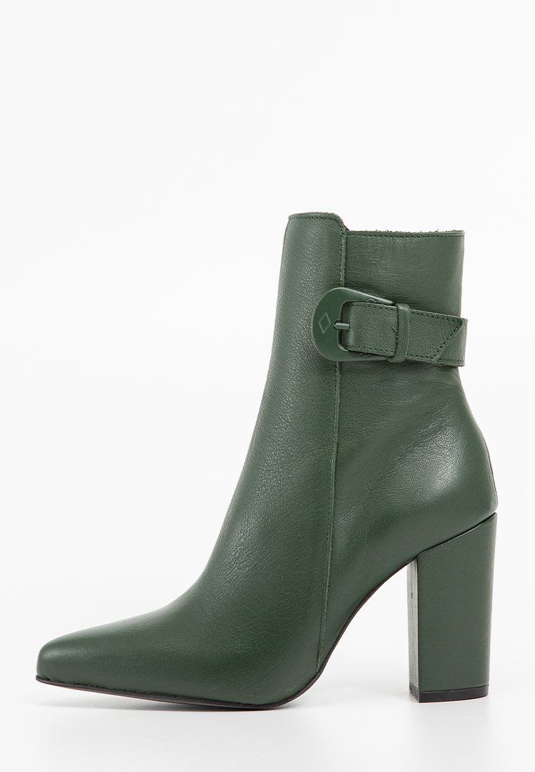 Zielona skórzana botka za kostkę z wysmuklonym noskiem, wysokim słupkowym obcasem i detalem w postaci zapięcia z boku. Gładka tekstura i wyraźnie zarysowany kształt.