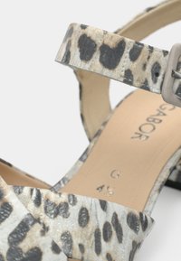 Πέδιλο με λουράκια και μοτίβο λεοπάρδαλης, τακούνι block, μπεζ εσωτερική σόλα με το όνομα της μάρκας, μέγεθος 4½, και κούμπωμα με αγκράφα.