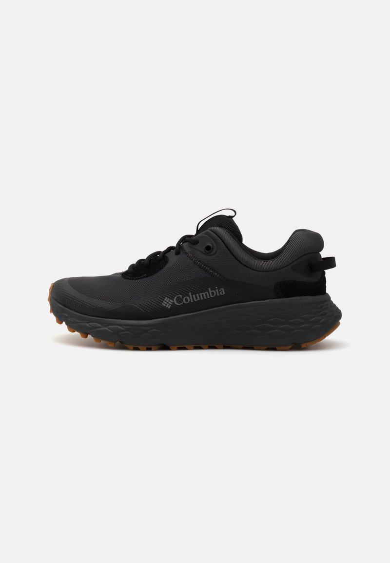 Baskets noires Columbia avec une surface texturée, un col rembourré et une semelle en caoutchouc présentant un motif distinct pour l'adhérence.