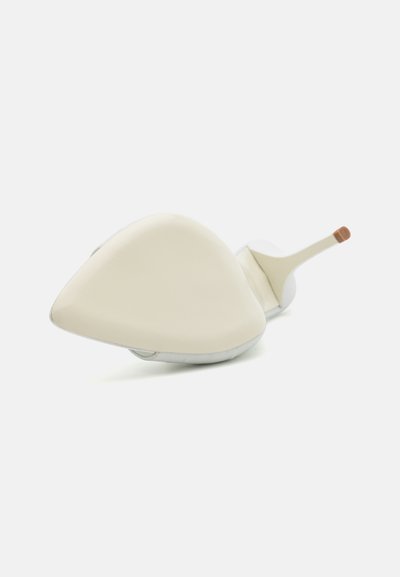 Zapato de tacón alto blanco con una punta afilada y un tacón esbelto. Presenta un diseño minimalista con un acabado brillante.