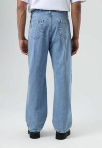 Lichtblauwe spijkerbroek met een losse pasvorm, voorzien van een hoge taille, twee achterzakken en zichtbare stiksels langs de naden.