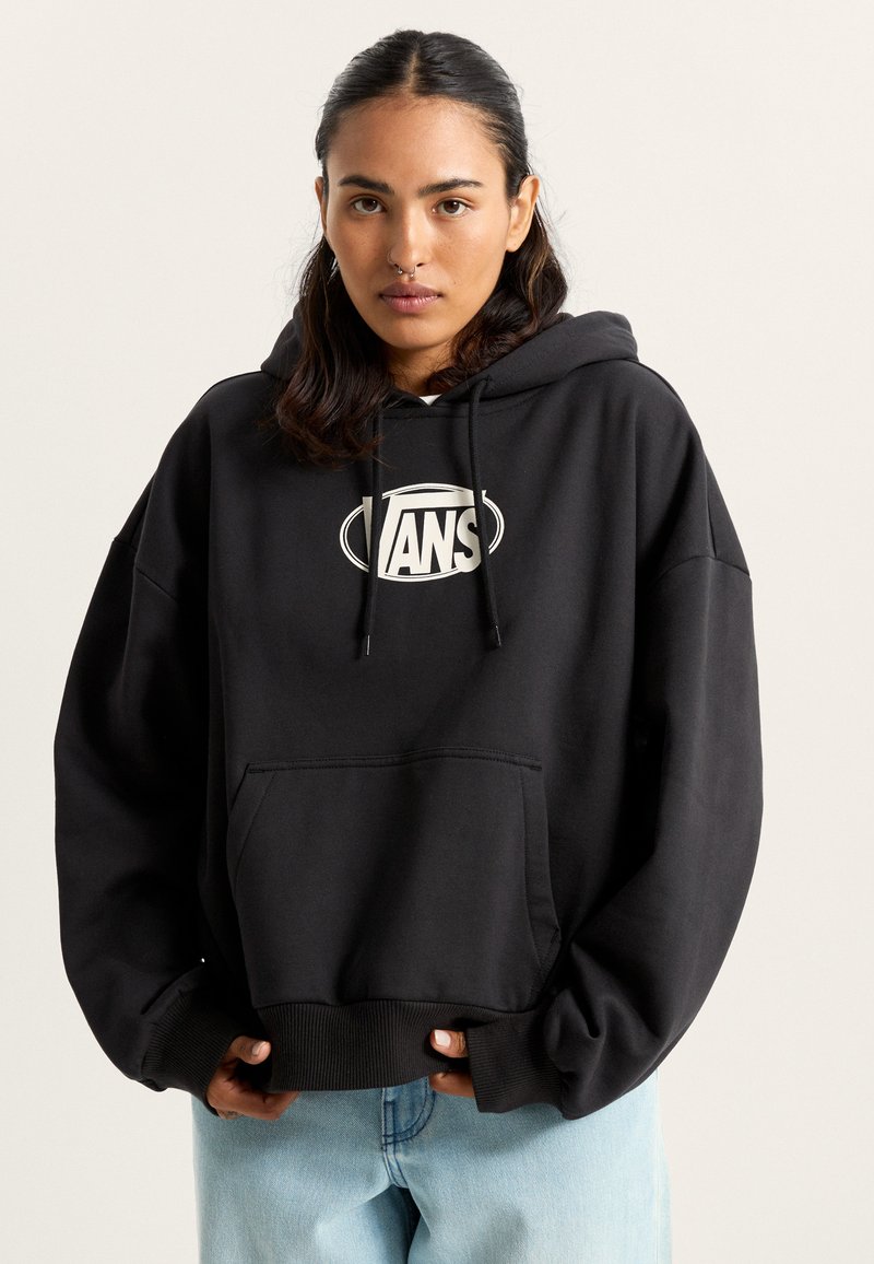 Sudadera negra de gran tamaño con bolsillo tipo canguro, capucha con cordón y logo blanco en el pecho. Puños y dobladillo acanalados; textura de tela suave.