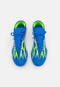 Scarpe sportive blu con tomaia texturizzata, dettagli giallo-verdi e strisce bianche, dotate di lacci tradizionali e colletto imbottito.