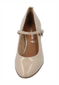 Chaussure Mary Jane en cuir verni beige avec un bout rond, un talon plat et une sangle réglable avec une boucle en argent.