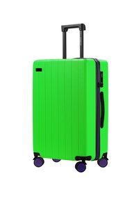 Zielona twarda walizka z teksturowaną powierzchnią, pionowymi żłobieniami, wysuwanym czarnym uchwytem, fioletowymi akcentami zamka błyskawicznego i czterema czarnymi kółkami.