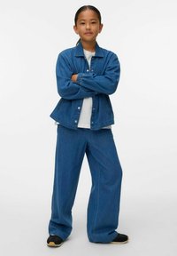 Denim jaka ar pogu aizdari un elastīgām piedurknēm, p�ārī ar platām denim biksēm. Abas detaļas ir vidēji zilā krāsā, brīvā piegriezumā.