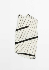 Udenærmet top i let stof, hvid med sorte diagonale striber, der har et unikt asymmetrisk design og sideknapdetaljer.