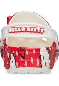 Zuecos de plástico rojos con una correa blanca y la marca "Hello Kitty", con un patrón de lunares y un gráfico del personaje en el lateral.