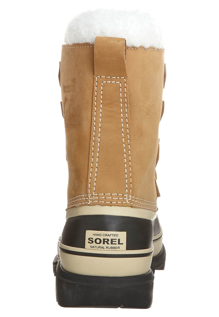 Botte en cuir tan avec doublure en fausse fourrure blanche, semelle en caoutchouc beige et accents cousus. Dotée d'une étiquette de marque le long du talon.
