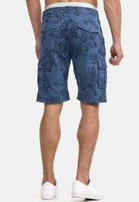 Blue cargo shorts with a floral pattern, featuring side pockets and a branded waistband, made from a lightweight fabric.