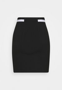 Svart figurnära miniklänning med hög midja och vita elastiska insatser med varumärke på en vit bakgrund.