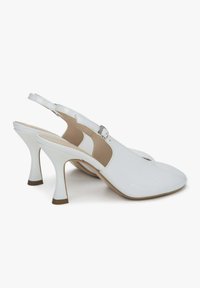 Witte slingback hakken met een puntige neus, glanzend materiaal en een unieke, gebogen hak. Bevat een dunne enkelband met een gesp.