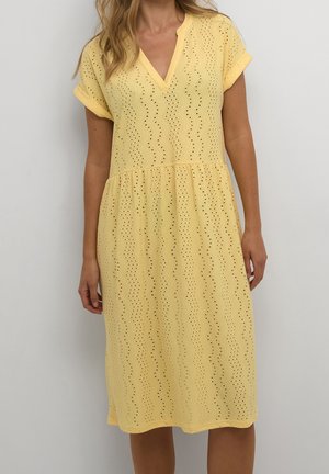 Gelbes Kleid mit V-Ausschnitt, kurzen Ärmeln und schichtweisem Design. Durchbrochenes Muster mit Zickzackstruktur. Lässiger Schnitt.