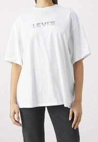 Camiseta blanca de gran tamaño hecha de algodón, con un logo gris de Levi's en el pecho, de mangas cortas y un ajuste relajado.