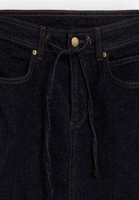 Donkere denim jeans met een trekkoord in de taille, een sluiting met gouden knoop en contrasterende oranje stiksels. Voorzien van zijzakken en een gladde textuur.