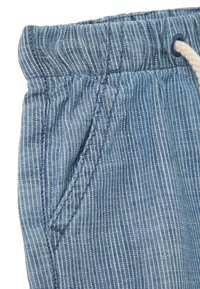 Shorts rayés bleu clair avec une taille élastique, dotés d'un cordon de serrage et de détails de poches latérales, fabriqués dans un tissu doux.