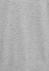 Hellgrauer Strickstoff mit glatter Textur, der einen gerippten Saum am unteren Ende aufweist. Keine sichtbaren Muster oder zusätzlichen Details.