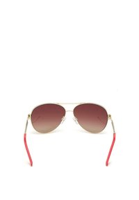 Gafas de sol estilo aviador con lentes marrones degradados, montura de metal dorado y brazos de plástico rojo. Cuenta con almohadillas nasales transparentes para mayor comodidad.