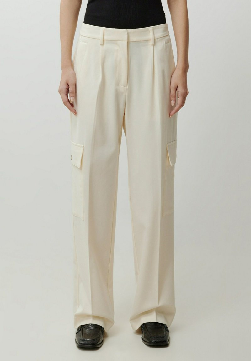Beige wijde broek van gladde stof, met twee voorzakken, een vlakke voorkant, plooien en een getailleerde pasvorm.