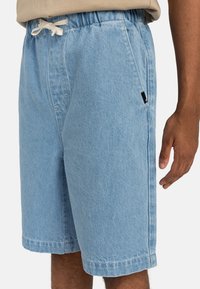 Svetlomodré denim šortky s elastickým pásom, šnúrkou, bočnou kapsou a malou čiernou nášivkou na ľavom bočnom šve.
