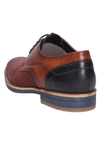 Bruine en zwarte leren schoen met een gestructureerde voorkant, contrasterende hak en een blauwe rubberen zool. Voorzien van veters en een comfortabele binnenvoering.