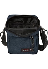 Sac bandoulière en tissu bleu marine avec un compartiment principal zippé, des poches intérieures, une bandoulière réglable et un logo Eastpak à l'avant.