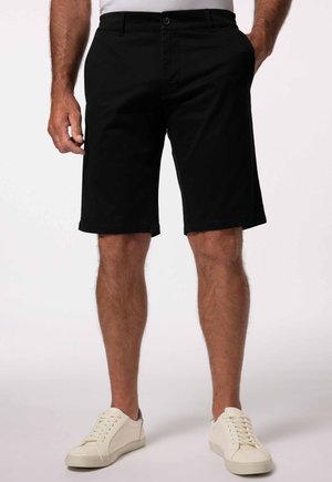 Zwarte shorts van een katoenmix, met een rechte pasvorm en zijzakken, gecombineerd met crèmekleurige sneakers.