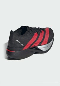 Black running shoe with red stripes, textured upper, and silver accents. Features a cushioned sole labeled "LIGHTSTRIKE PRO."