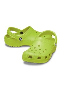 Zuecos de color verde brillante, hechos de plástico ligero y duradero. Cuentan con orificios de ventilación, una correa posterior y suelas texturizadas para mayor tracción.