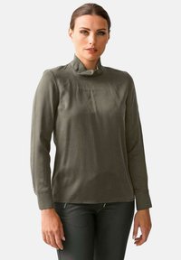 Olivgrünes Langarmhemd mit ste Hend. Glatter Stoff, taillierte Passform und gepuffte Ärmel. Minimalistischer Stil, keine Muster oder Metallteile.