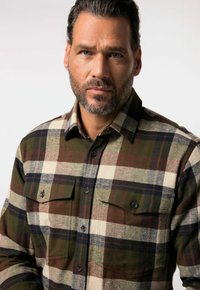 Kariertes Flanellhemd in Grün, Braun, Weiß und Marineblau. Knopfleiste vorne, zwei Brusttaschen mit Klappen und strukturierter Stoff.