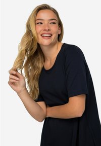 Navy blue short-sleeve top in a relaxed fit, featuring a round neckline and smooth fabric. The design emphasizes comfort and ease of movement.