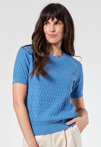 Lyhythihainen sininen neulepaita, joka on valmistettu teksturoidusta neulekankaasta, ja siinä on pyöreä pääntie sekä resorit hihansuissa ja helmassa; rento istuvuus.