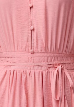 Rotes Kleid mit gerafftem Stoff, runden Knöpfen und gebundenem Bund. Weiche Textur mit vertikalen Nähten und ausgestelltem Saum.