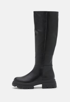 Tall black leather boots with a sleek design, rounded toe, chunky black rubber sole, and minimal stitching details along the sides.