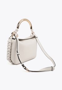 Läderhandväska i ljusgrått med flätad sidodetalj, guldfärgad hårdvara och avtagbar svart axelrem. Minimalistisk design.