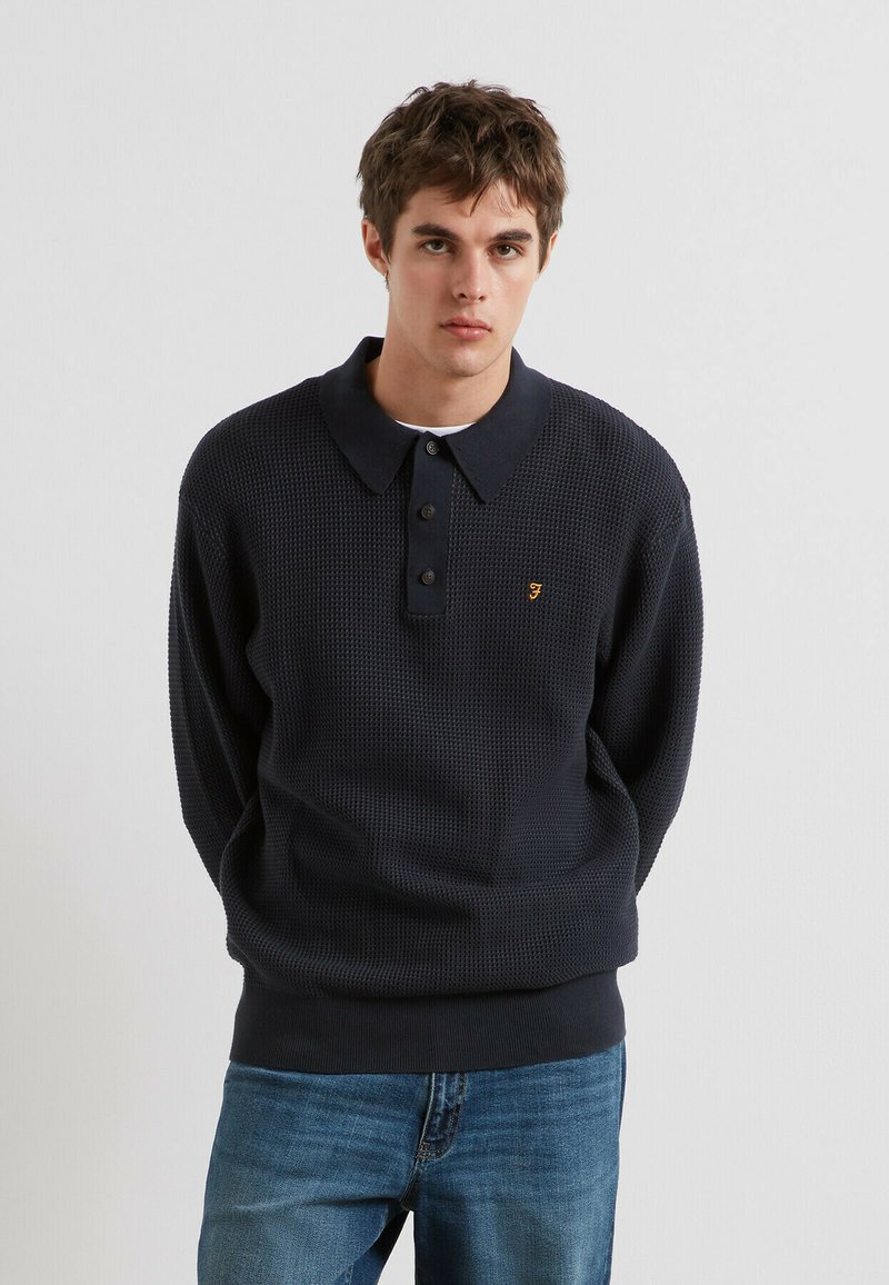 Marineblauw gebreid poloshirt met een gestructureerd patroon, voorzien van een knoopsluiting en een geborduurd logo op de borst.Casual pasvorm.