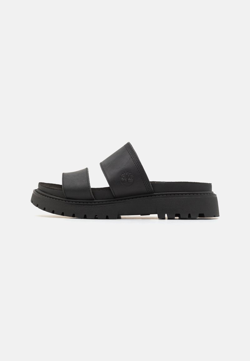 Sandale slide noire avec deux larges brides en cuir et semelle épaisse à crampons, logo Timberland embossé sur la bride supérieure.