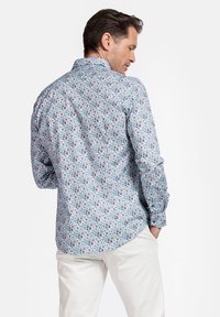 Lange mouwen shirt in lichtblauwe katoen met een bloemenpatroon in verschillende kleuren. Voorzien van een button-down kraag en standaard manchetten.