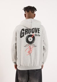 Gray hoodie with a front kangaroo pocket, featuring a graphic print of a hand holding a flower stylized as a vinyl record on the back.