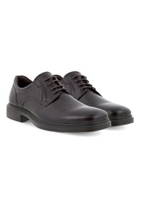 Scarpe in pelle marrone con punta arrotondata, chiusura con lacci e suola nera in gomma bassa. Presentano leggere cuciture decorative e una finitura liscia.