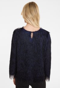 Dunkelblauer, flauschiger Pullover aus einem strukturierten, langhaarigen Stoff, mit Dreiviertelärmeln und einem kleinen Schlüsselöffnungsdesign auf der Rückseite.