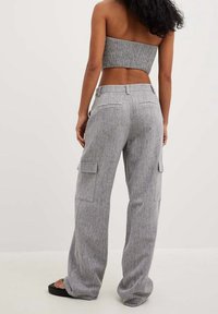 Grijze, textuur cargo broek met zijzakken en een relaxte pasvorm, gecombineerd met een gesmokt, strapless top. Minimalistisch ontwerp.