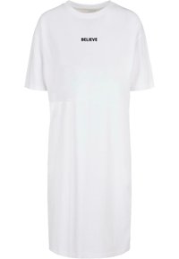 Balta per didelį dydį t-shirt suknelė, pagaminta iš medvilnės, trumpomis rankovėmis ir apvaliu kaklu. Priekyje yra juodu tekstu užrašas "TIKĖK".