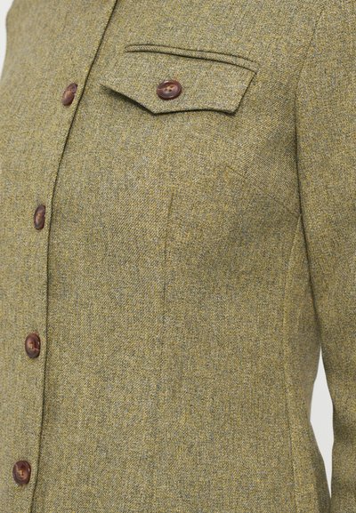 Olivinės spalvos tweed švarkas su tekstūruotu paviršiumi, turintis krūtinės kišenę, šešis rudus mygtukus ir pritaikytą siluetą.